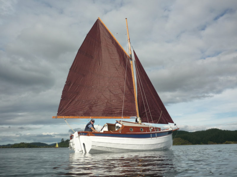 WHIO's gaff rig carries 235 sq ft of sail. When the wind fails, an outboard mounted forward of the transom provides power. The notch in the transom allows the motor to be kicked up.