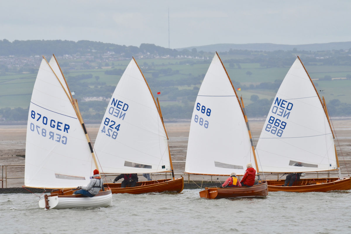 Five dinghies come about in the 100th anniversary race at West Kirby. The woman skippering the Dutch entry #688 is 81 year old Tonnie Surendonk.