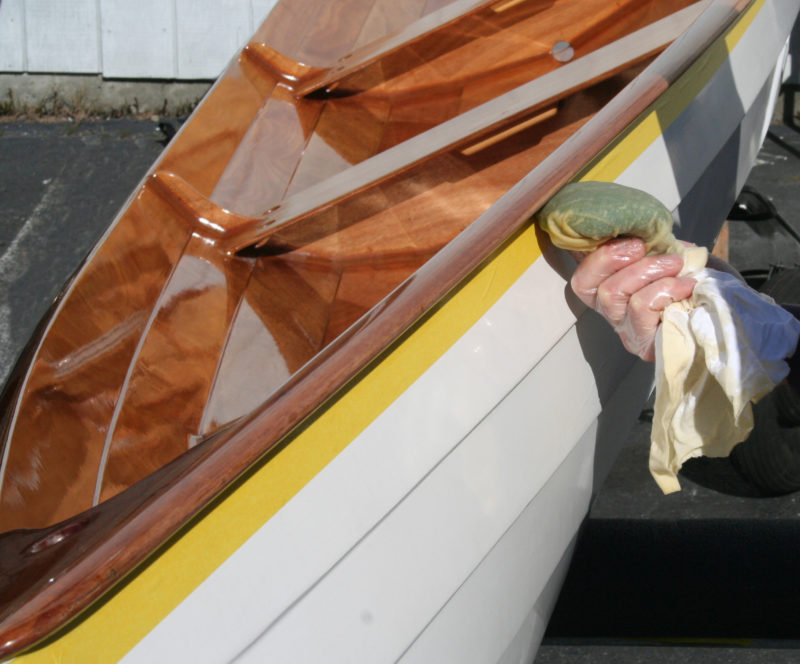 With masking tape protecting the painted hull Don can moving with the speed necessary to wipe on the thinned varnish.