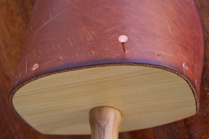 Pilot holes drilled in the leather and bailer back will allow you to hammer 3/4" copper tacks in without having the buckle or hook around in the wood.