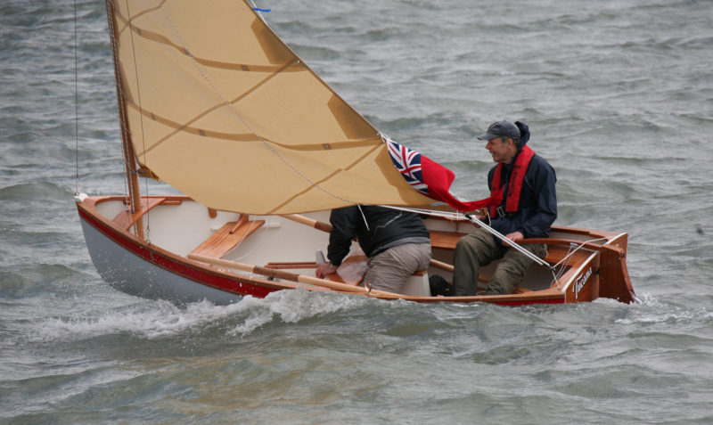 While the builder mans the helm and the sheet, the crew keeps his weight aft and is ready to respond to gusts.