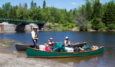 The put-in on Lobster Stream is just upstream of its confluence with the West Branch of the Penobscot River. We were all excited, a tad anxious, and already tired following the long journey from home. The 2-mile paddle up to Lobster Lake is, strictly speaking, upstream but in practice it’s an easy flat water trip. TINTIN, in the foreground, carries gear for a family of four.