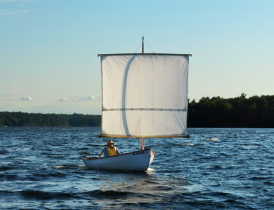 Reaching in about 12 mph wind, with whitecaps beginning to form. It will soon be time to reef. The upper yard is suspended from a pair of ‘lifts’ that spread load on the spar and also raise the pivot point. The downhaul next to the mast can tension the lower spar as needed and transfers sail thrust to the hull, reducing strain on the pair of sheets attached to the lower corners.