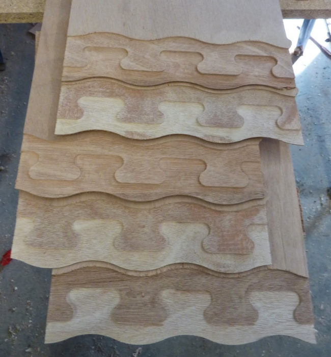 The CNC-cut joints in the long plywood panels are cut with three levels. The middle level is designed to lock the pieces together. The outer levels have an undulating curve that avoids the weakness of a straight butted edge and offers a more pleasing appearance than a jigsaw joint.