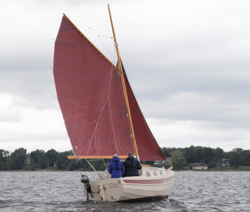 The gaff rig is one of three options for the Penguin. The Bermudan main rig, like the gaff rig, has the mast stepped on the cabin roof. A yawl rig has a leg o' mutton mizzen, tit's mast offset to clear the tiller, and a mainmast stepped on the foredeck. Here, STELLA MARIS has a bracket for it's auxiliary outboard. The plans include a motor well with a notch in the transom for kicking the motor up while under sail.