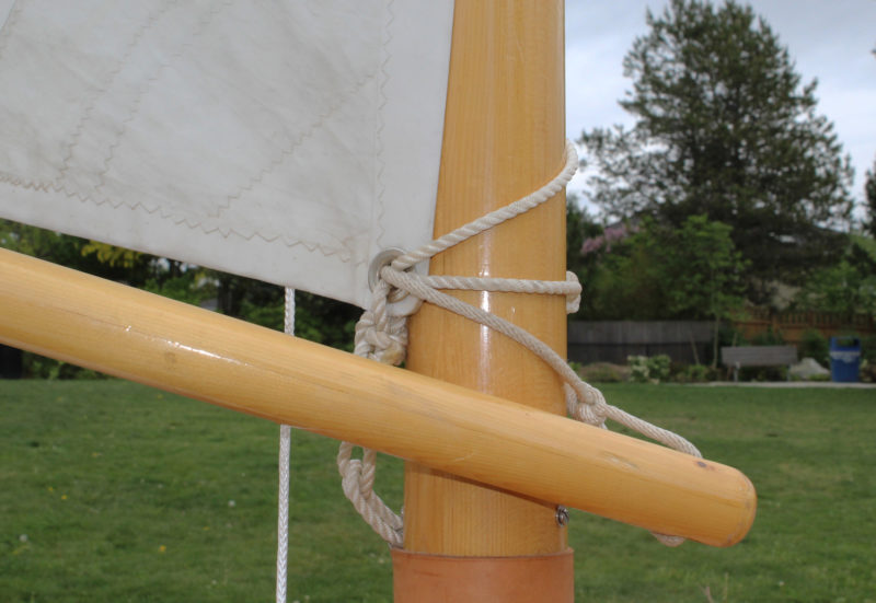 A line though the tack and around the mast with a loop tied in it holds this boom in position for brailing.