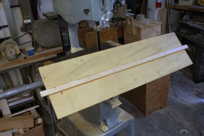 The hardwood runner glued to the bottom of the plywood fits the miter gauge slot in the bandsaw table. The extra bit extending beyond the plywood makes it easier to locate the runner in the slot.