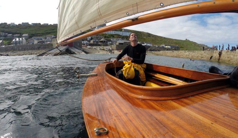 Leaving Sennen, Will keeps an eye on the sail as we round the end of the breakwater. His 15’ Expedition Boat was a development of his standard 14’ dinghy with side decks and a longer foredeck added to provide more protection from the elements.