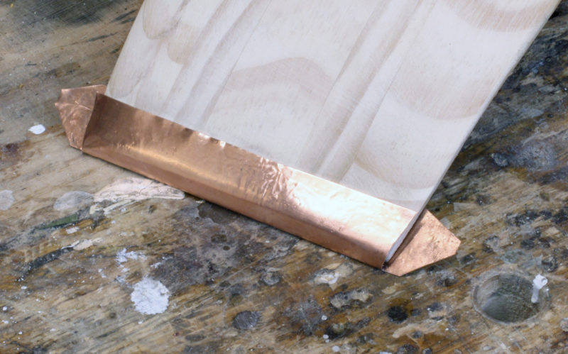 The copper, with the table on the concave side of the blade, gets formed round the tip.