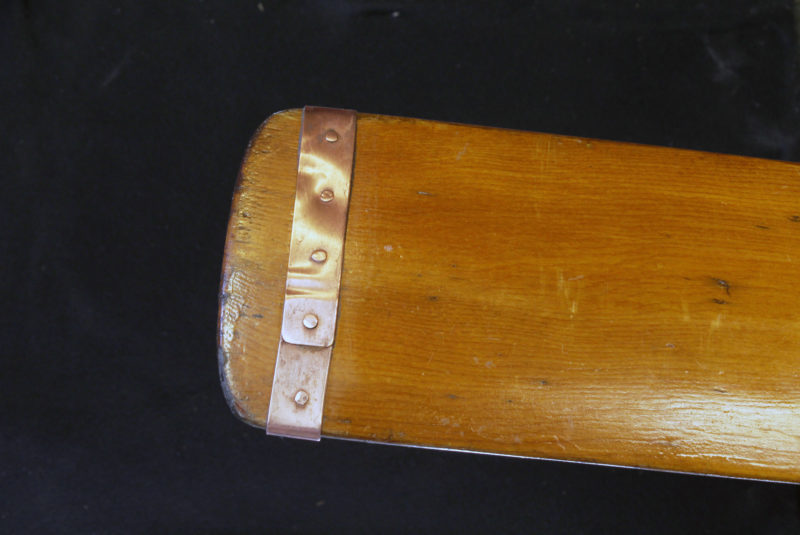 A simple flat band around a straight-bladed oar is a tradition method for preventing a blade from splitting. It doesn't protect the tip from wear.