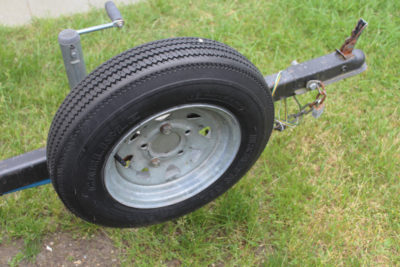 This trailer tire looks brand new—it still has all of the little rubber "hairs" left by the the mold that created it—but the codes molded into the sidewall indicate it is 16 years old. It needs to be replaced.