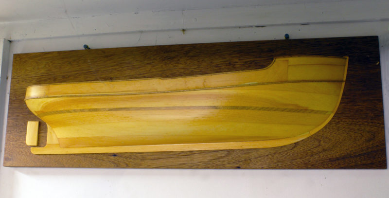 There are no markings in this half hull. Phil did some work designing commercial vessels and this may be one of them. It hangs in a room adjoining the shop, a windowless room lined with bookshelves.
