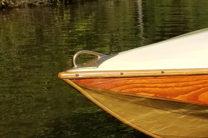 The bow handle's base plate is curved to fit the breasthook beneath the stretched and painted canvas deck.