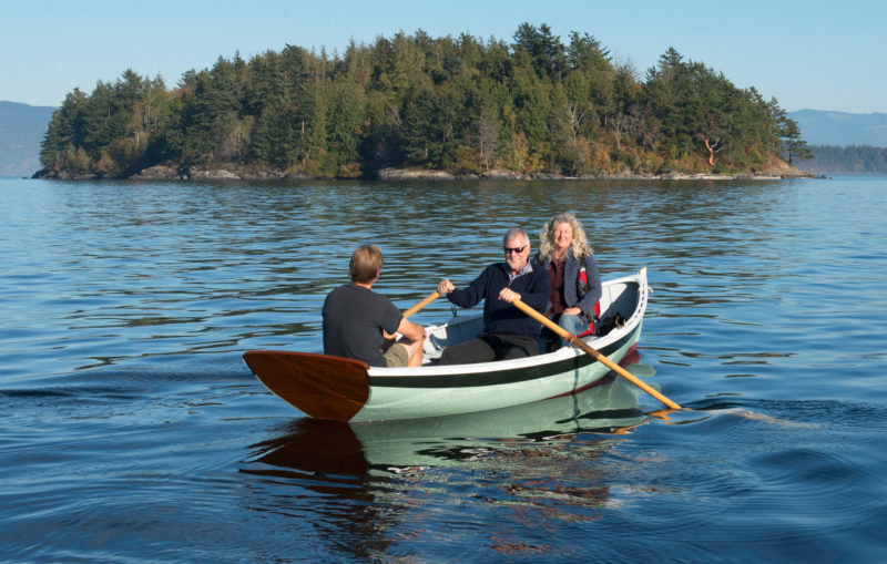 With three aboard, the dinghy rests lightly on the water with only a bit of the transom immersed.