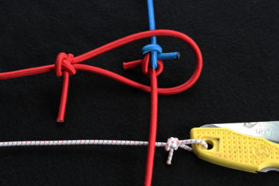 The Angler's Loop (both horizontal) and the Zeppelin Bend (vertical) will hold in bungee cord without coming undone or jamming.