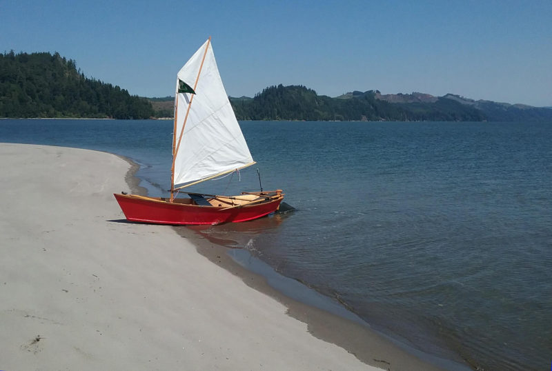 Her sail set for the midday breeze, KIMCHI rests on the beach of Jim Crow Sands. To the northeast, across the shipping channel, lies the Washington shore. Most of Jim Crow Sands is dredge spoil, pumped up from the bottom of the channel.