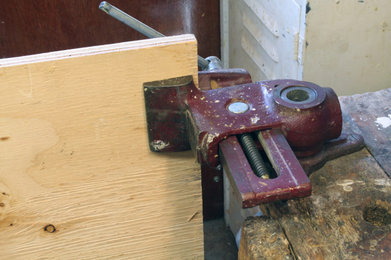 With the vise on its side and its jaws facing outward, a sheet of plywood, resting on edge on the floor, can be held upright.