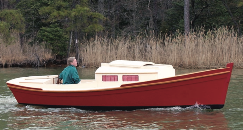 Man pilots his Redwing outboard skiff cruiser along the water.