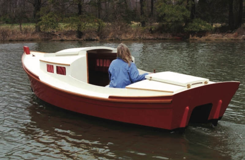 Woman wearing a blue jacked in a Redwing outboard cruiser on the water.