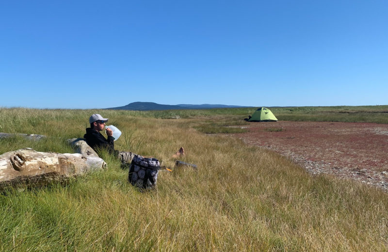 Tom, sitting in the foreground, gives perspective. Acadia Mountain towering in the background makes the dome tent look tiny.
