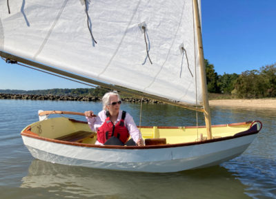 Woman Guiding a Nutshell Sailing Pram by Rudder