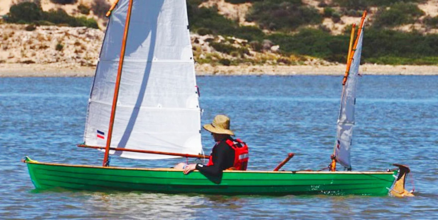 Cropped photo of MacGregor canoe being piloted by sailor.