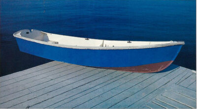 Color photo of blue rowboat sitting on a dock.