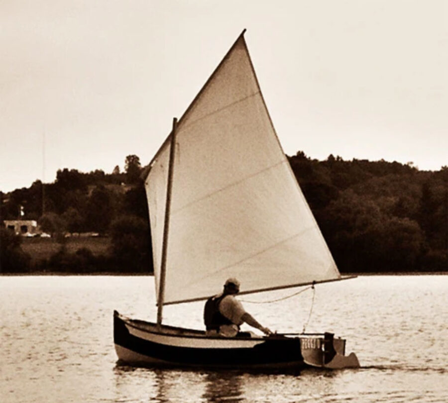 Sepia-toned photograph of man in a small Annabelle sailing skiff.