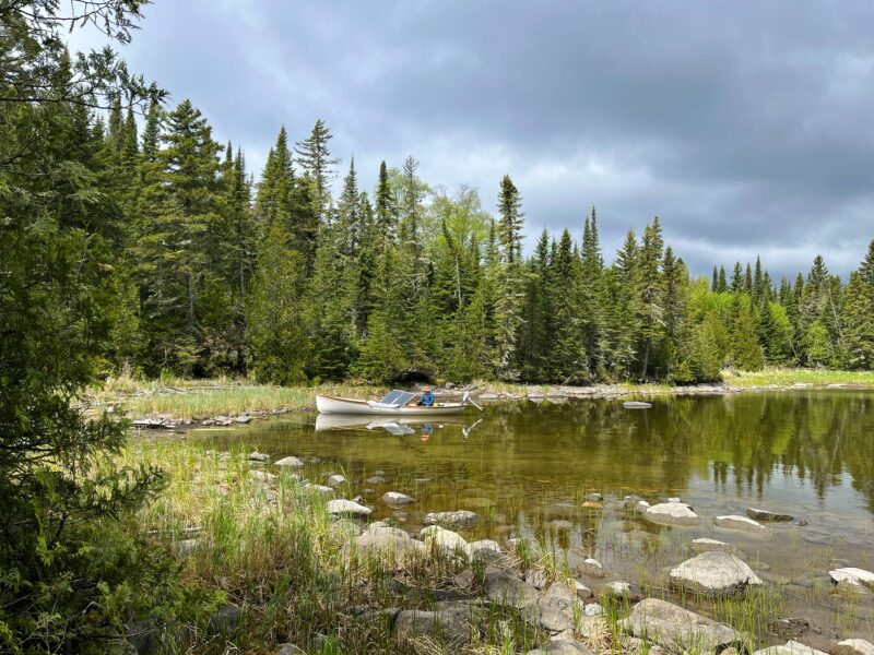 White boat with solar panels anchored at Fishhook Island while cruising Lake Nipigon.