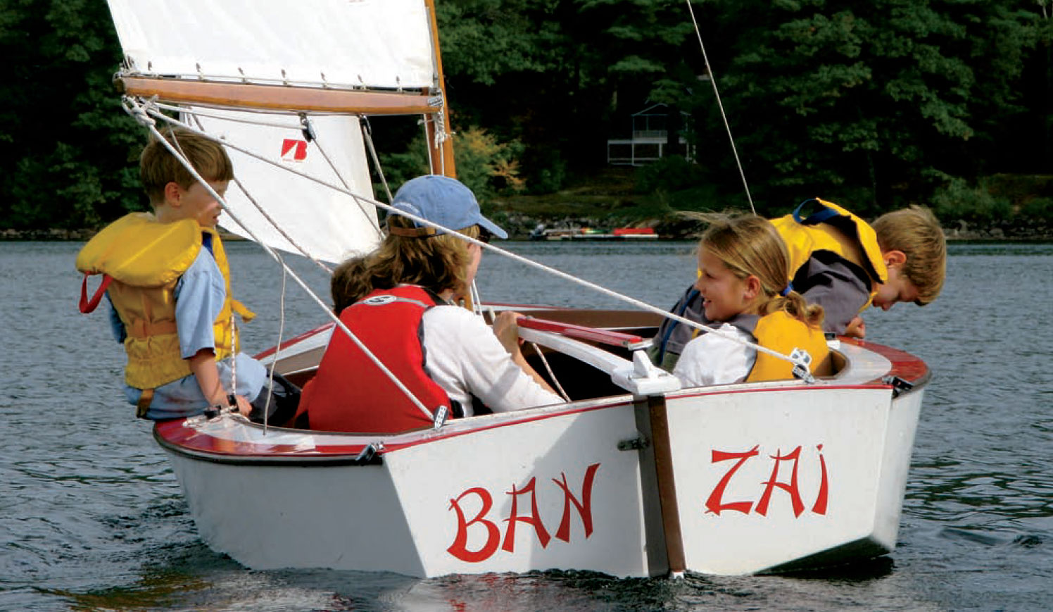 Woman and a group of children sail the Blue Jay-class sloop, Banzai.