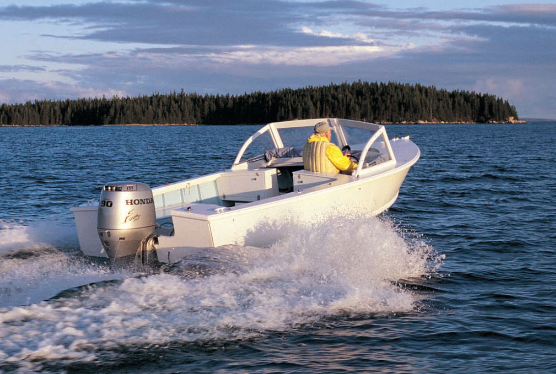 Man wearing a yellow jacket pilots a white Albury runabout powerboat.