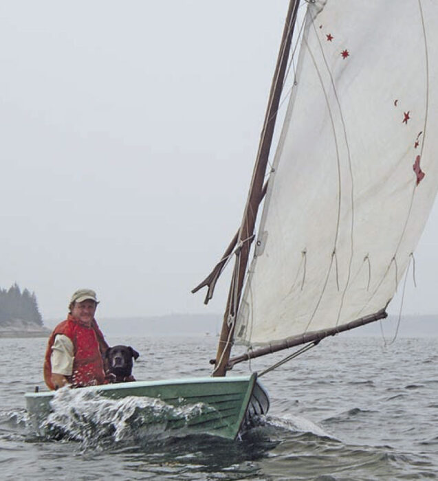 Man and his dog aboard a Delaware Ducker sailboat.