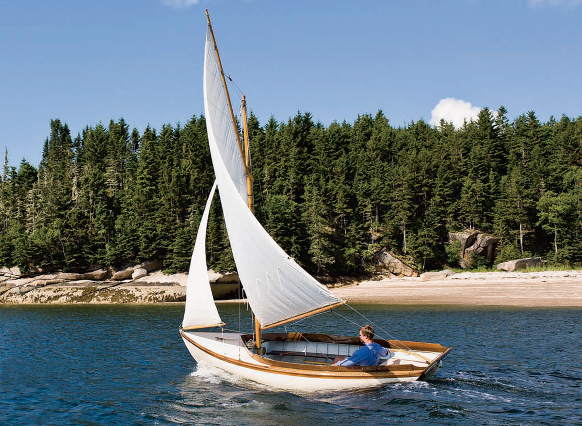 Man riding in a Haven 12 1/2 footer with white sails.