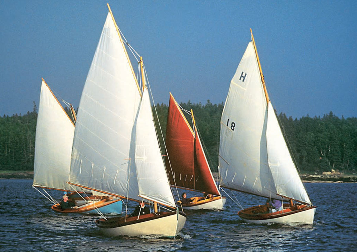 Four small sailboats in the water at WoodenBoat School.