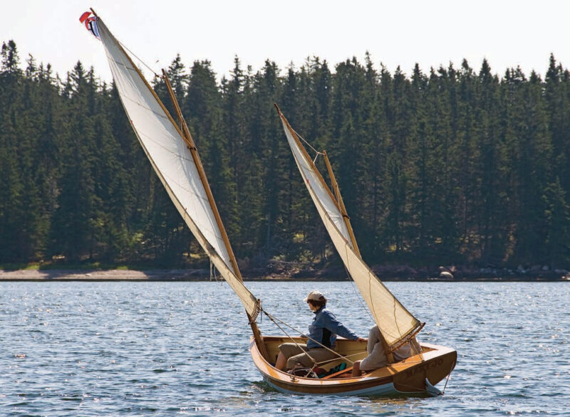 Two sailors aboard a Coquina yacht with two sails.