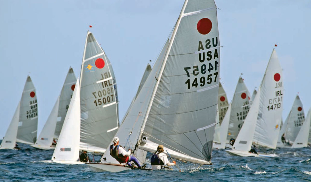 A group of International Fireball racing boats in the water.