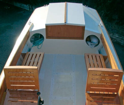 Interior view of Ninigret powerboat with wooden seats and stowed equipment.