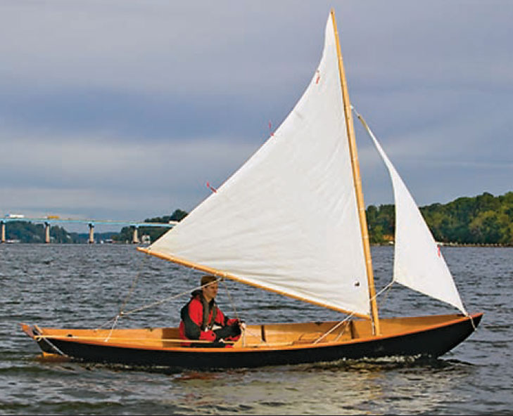 Man sails a Northeaster Dory with white sails.