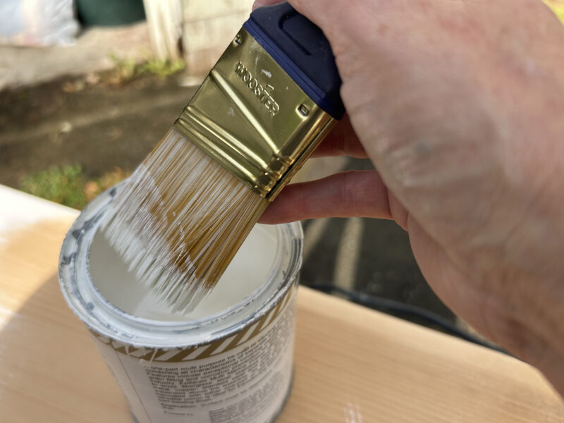 Wooster Shortcut paintbrush dipping into a can of paint