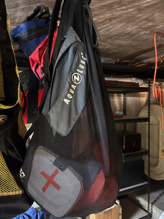 Mesh bag with first aid kit hung in dry storage for winter