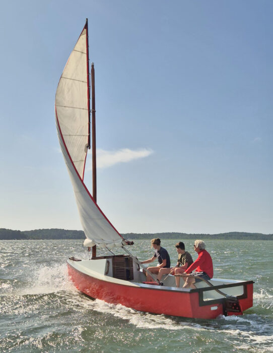 Sailing scow Voilier Nord Bassin sailing under reefed mainsail in stiff breeze.