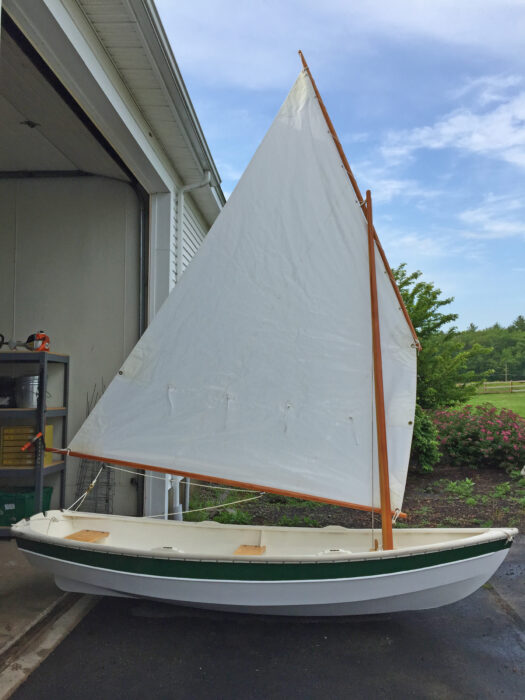 Shellback Dinghy rigged outside a garage.