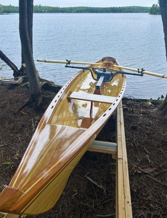 Strip-planked rowing shell with sliding seat mechanism