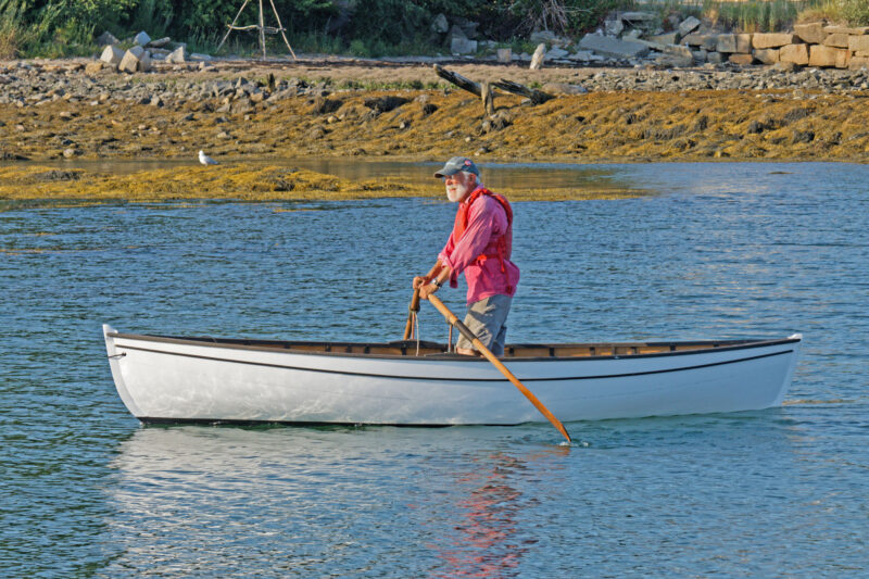 Whitmore peapod with man standing up and rowing facing forward