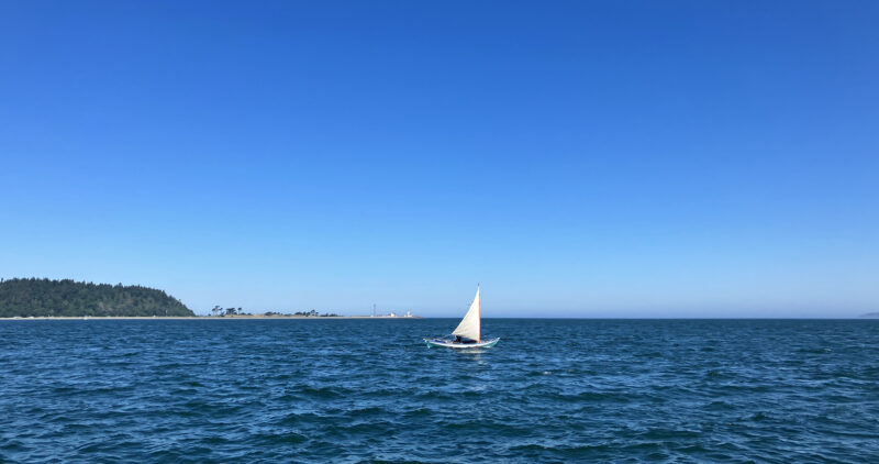 Sailing dory under blue skies 