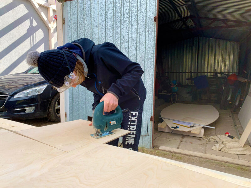 Boy cuts plywood with Black and Decker saw