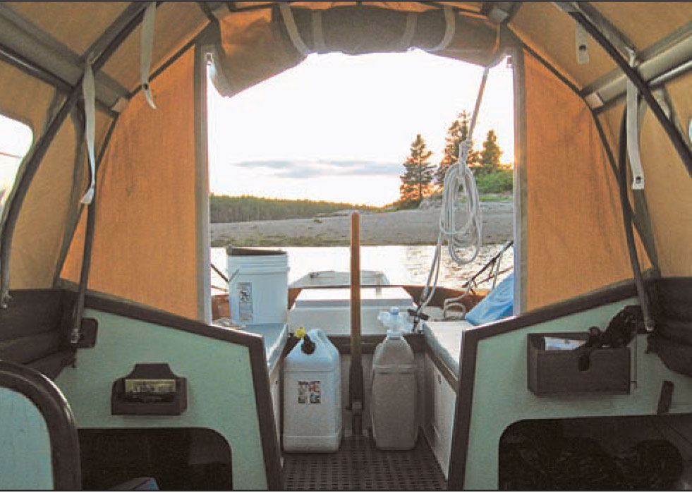 View of the horizon and water from inside a small boat cabin.