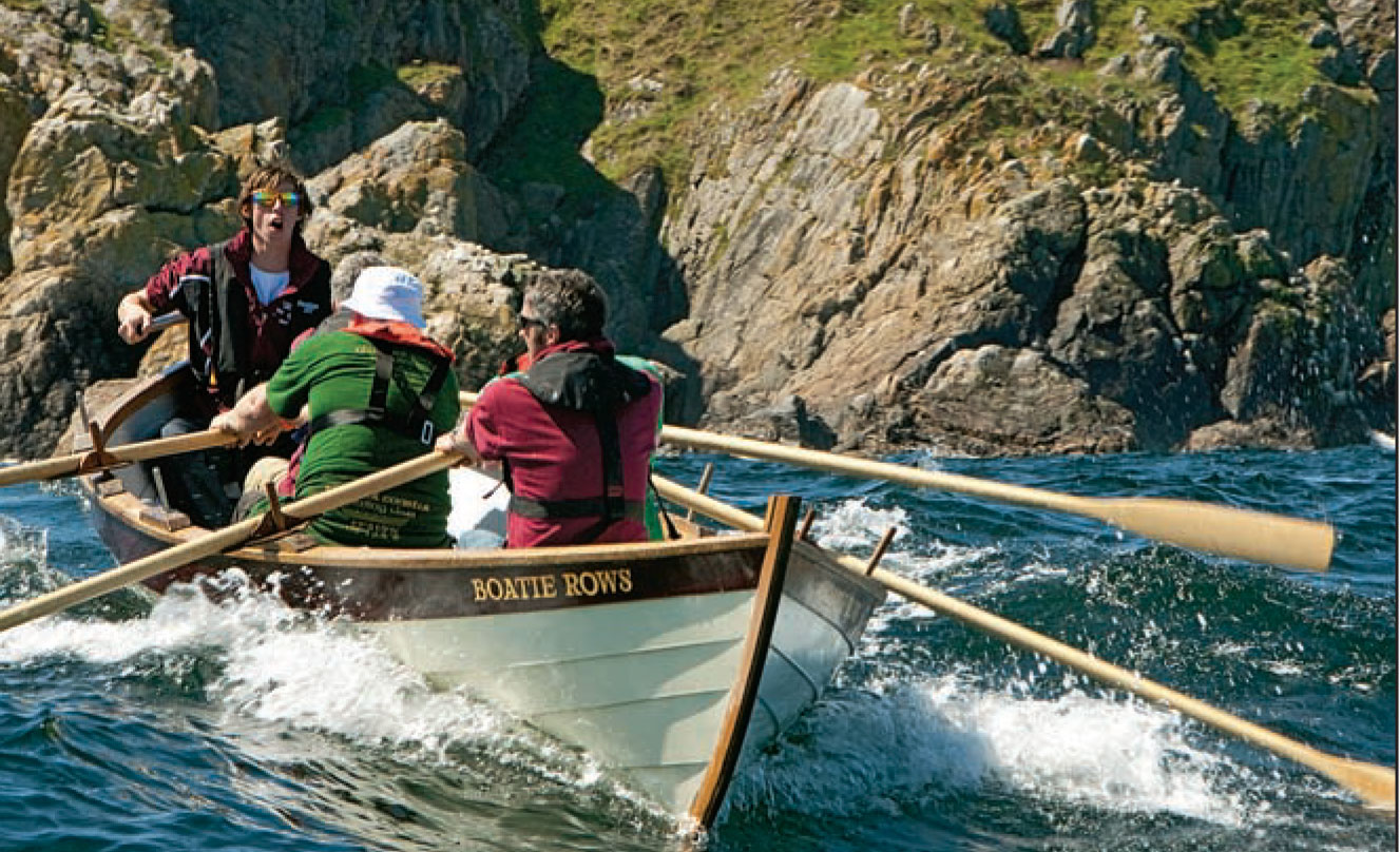 Rowing team rows their skiff through chop.
