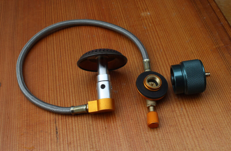 Connecting hose plus connector for hooking up propane cannister to nCamp stove.