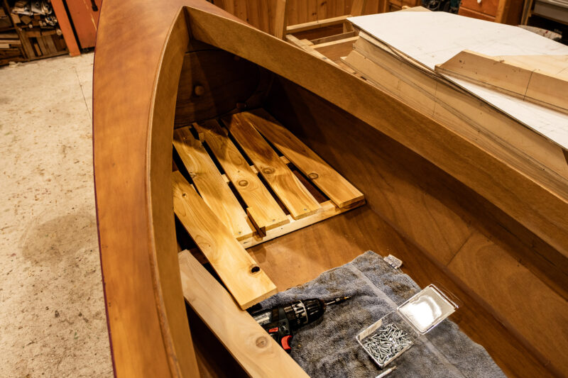 Sectional floorboards under construction in wooden double-paddle canoe.